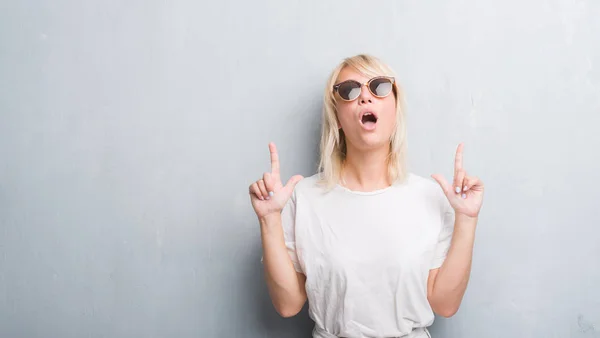 Erwachsene Kaukasische Frau Über Grunge Grauer Wand Mit Sonnenbrille Staunend — Stockfoto