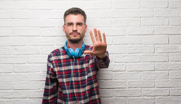 Hombre Adulto Joven Sobre Pared Ladrillo Con Auriculares Con Mano — Foto de Stock