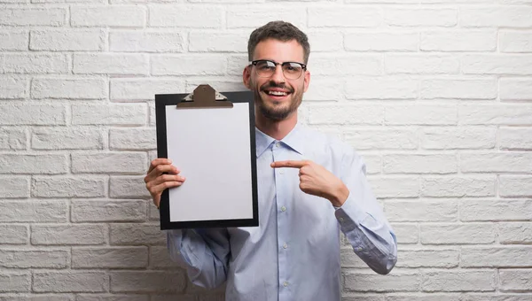 Joven Adulto Hombre Negocios Sobre Pared Ladrillo Sujetando Portapapeles Muy —  Fotos de Stock