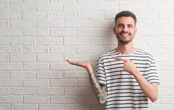 Homem Adulto Jovem Sobre Parede Tijolo Branco Muito Feliz Apontando — Fotografia de Stock