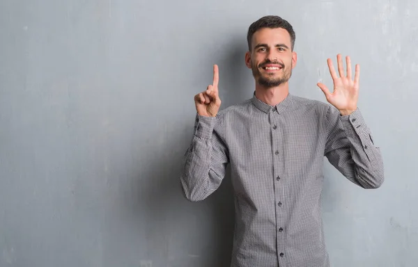 Joven Hombre Adulto Pie Sobre Pared Grunge Gris Mostrando Apuntando —  Fotos de Stock