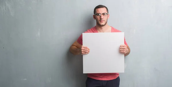 Young Caucasian Man Grey Grunge Wall Holding Blank Banner Confident — Stock Photo, Image