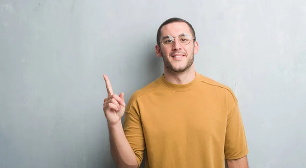 Joven Caucásico Hombre Sobre Gris Grunge Pared Sorprendido Con Una —  Fotos de Stock