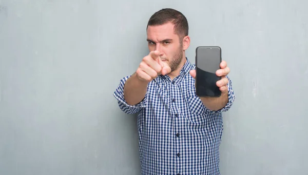 Joven Hombre Caucásico Sobre Pared Grunge Gris Que Muestra Pantalla — Foto de Stock