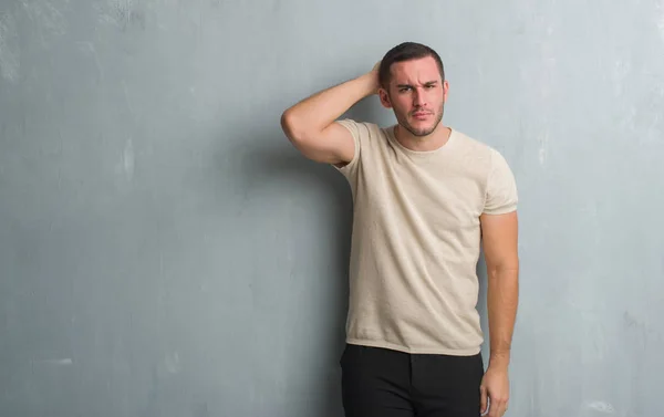 Joven Caucásico Hombre Sobre Gris Grunge Pared Confundir Preguntarse Acerca — Foto de Stock