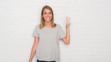 Güzel ve genç birbayan gösterilen ve parmakları ile işaret beyaz tuğla duvarın üzerinden üçüncü ise kendinden emin ve mutlu gülümseyerek.