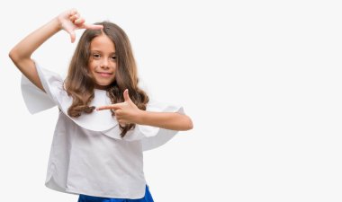 Elle yapma çerçeve ve parmakları ile mutlu yüz gülen esmer İspanyol kız. Yaratıcılık ve Fotoğrafçılık kavramı.