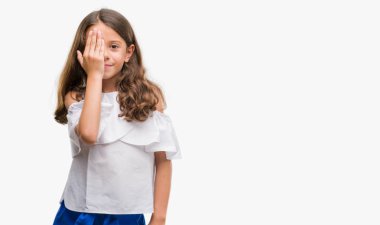 Esmer İspanyol kız yüz ve sürpriz duygu kendinden emin gülümseme ile el ile bir göz kapsayan.