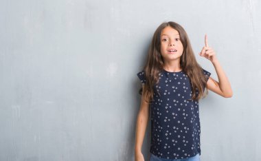 Grunge gri duvar işaret parmağı kadar başarılı fikir genç İspanyol çocuk. Çıktıktan ve mutlu. Bir numara.