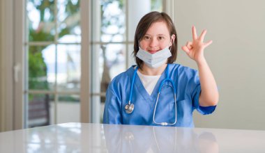 Down syndrome woman wearing nurse uniform doing ok sign with fingers, excellent symbol clipart