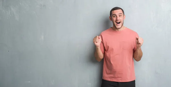 Kaukasische Jongeman Het Vieren Van Muur Van Grijze Grunge Verrast — Stockfoto