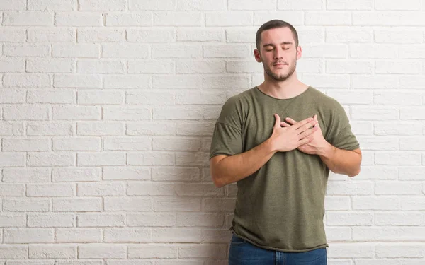 Young Caucasian Man Standing White Brick Wall Smiling Hands Chest — Stock Photo, Image