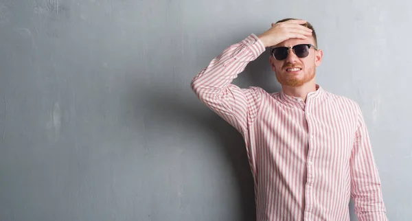 Joven Pelirrojo Sobre Pared Grunge Gris Con Gafas Sol Estresadas — Foto de Stock