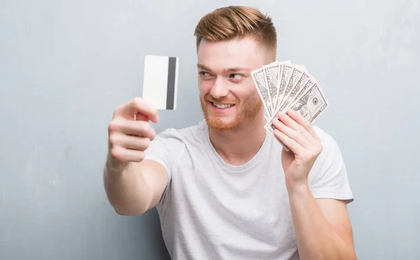 Young Redhead Man Holding Dollars Credit Card Smiling Looking Side — Stock Photo, Image