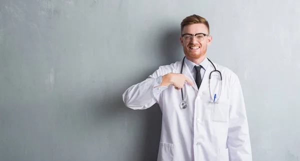 Joven Pelirroja Doctor Hombre Sobre Gris Grunge Pared Con Sorpresa — Foto de Stock