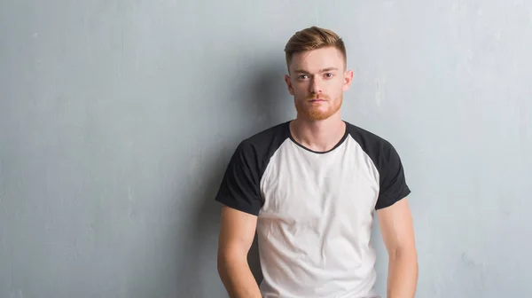 Genç Kızıl Saçlı Adam Gri Grunge Duvarın Yüzünde Ciddi Bir — Stok fotoğraf