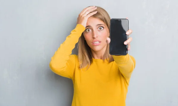 Beautiful Young Woman Grunge Grey Wall Showing Smartphone Screen Stressed — Stock Photo, Image