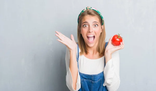 Belle Jeune Femme Sur Mur Gris Grunge Manger Tomate Fraîche — Photo