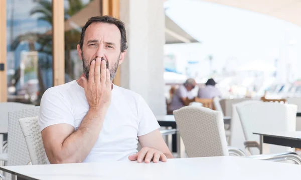 Hombre Mayor Guapo Sentado Terraza Cubrir Boca Con Mano Conmocionado — Foto de Stock