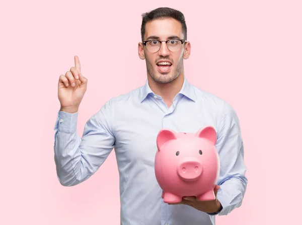Handsome Young Man Holding Piggy Bank Surprised Idea Question Pointing — Stock Photo, Image