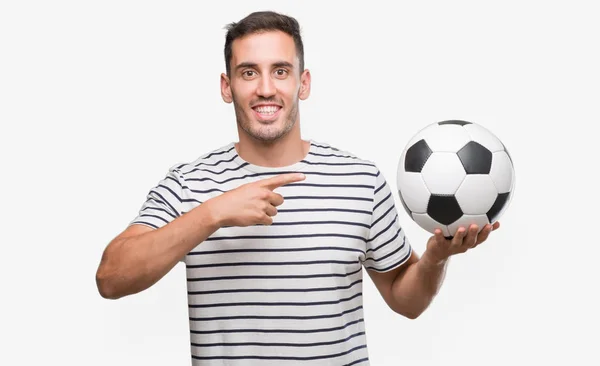 ハンサムな若い男の手と指で指している非常に幸せなサッカーを保持 — ストック写真