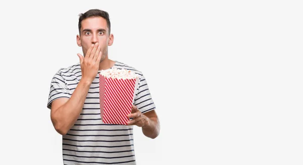 Bello Giovane Che Mangia Popcorn Coprire Bocca Con Mano Scioccato — Foto Stock