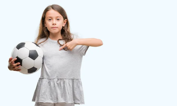 Brunetka Hispánský Dívka Drží Fotbalový Míč Fotbal Překvapením Tvář Ukazováčkem — Stock fotografie