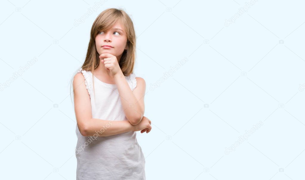Young blonde toddler serious face thinking about question, very confused idea