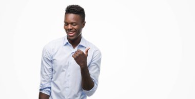 El ve parmak ile yukarı dönük mutlu yüz gülümseyen ile bir gömlek giymiş genç Afro-Amerikan adam