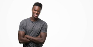 Gri t-shirt mutlu yüz ile gülümseyen giyen genç Afro-Amerikan adam kameraya seyir silah geçti. Olumlu bir kişi.