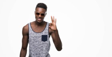 Afro-Amerikan delikanlı parmak, mükemmel sembolü ile ok işareti yaparken güneş gözlüğü takıyor