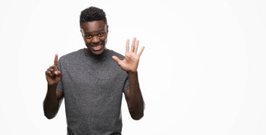 Gösterilen ve parmakları ile işaret gri t-shirt giyen genç Afro-Amerikan adam kendinden emin ve mutlu gülümseyerek süre 6 numara.