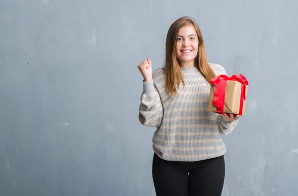 Young Adult Woman Grey Grunge Wall Holding Present Screaming Proud — Stock Photo, Image