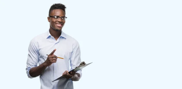 Young African American Man Holding Clipboarad Surprised Idea Question Pointing — Stock Photo, Image