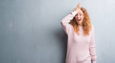 Genç redhead gri grunge duvar giyen üzerinde pembe kadın kazak kafasına hata için el ile sürpriz hata hatırlıyorum. Unuttum, kötü bellek kavramı.