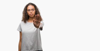 Stop yapıyor güzel genç İspanyol kadın gözlük elin avuç ile şarkı. Negatif ve ciddi bir jest yüz ifadesiyle uyarı.