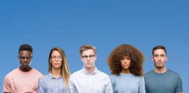 Yüzünde ciddi bir ifade ile mavi blackground üzerinde arkadaş grubu bileşimi. Basit ve doğal kameraya bakıyor.