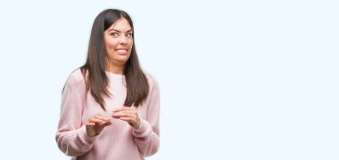 Bir kazak giyen genç güzel İspanyol kadın tiksinti ifadesi, memnun ve korkulu tiksinti yüz yapıyorsun çünkü nefret tepki. Elleriyle kaldırdı. Sinir bozucu kavramı.