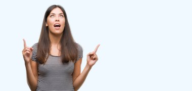 Genç güzel İspanyol kadın hayrete ve yukarıya bakıp parmakları ile işaret şaşırttı ve silah kaldırdı.