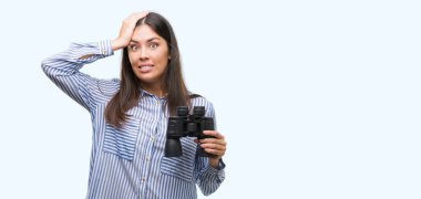 Genç İspanyol kadın holding dürbün kafasına, utanç ve sürpriz ile şok el ile vurguladı yüz, öfkeli ve sinirli. Korku ve hata için üzgün.