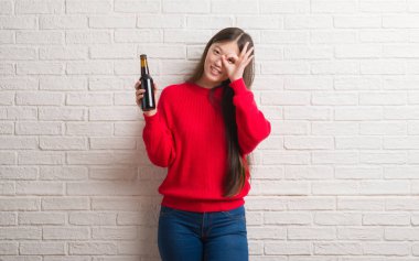 Mutlu yüz el parmaklarının arasından seyir göz üzerinde ok işaretiyle yapıyor gülümseyen ile bira içme tuğla duvarın üzerinden Genç Çinli kadın