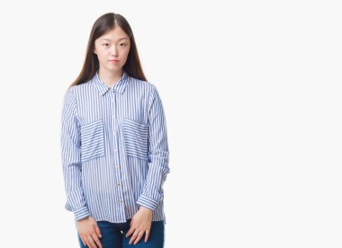 Yüzünde ciddi bir ifade ile izole arka plan üzerinde Genç Çinli kadın. Basit ve doğal kameraya bakıyor.