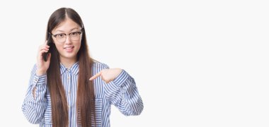 Kendisi için sürpriz yüz işaret parmağı ile telefonda konuşan izole arka plan üzerinde Genç Çinli kadın