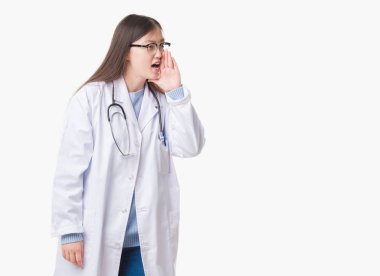 Genç Çince bağırarak ve ağzı üzerinde el ile yan için çığlık izole arka plan üzerinde kadın doktor. İletişim kavramı.