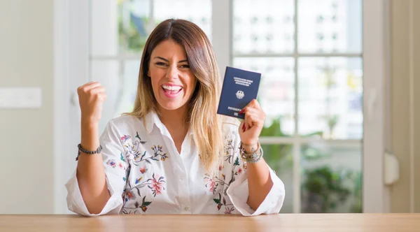 Young Woman Home Holding Passport Germany Screaming Proud Celebrating Victory — Stock Photo, Image