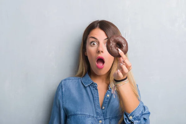 Mujer Adulta Joven Sobre Pared Grunge Gris Comiendo Donut Chocolate —  Fotos de Stock