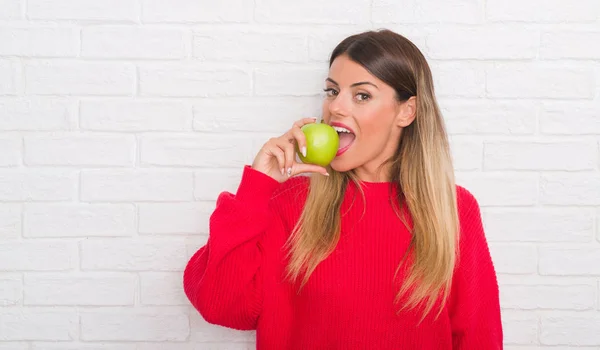 Mujer Adulta Joven Sobre Pared Ladrillo Blanco Comiendo Manzana Verde — Foto de Stock