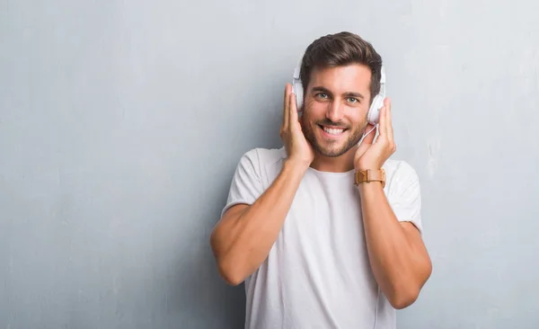 Handsome Young Man Grey Grunge Wall Wearing Headphones Listening Music — Stock Photo, Image