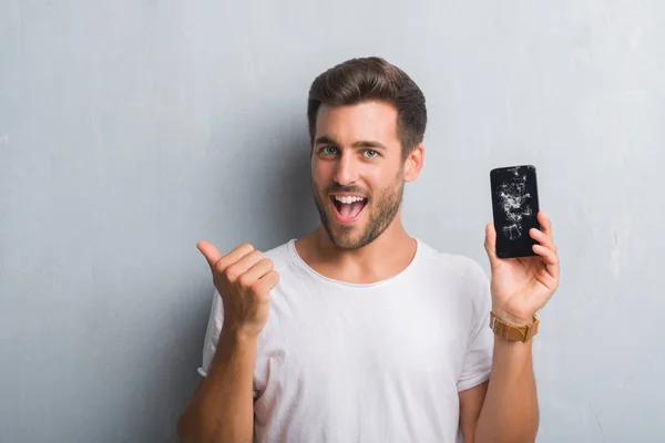 Schöner Junger Mann Über Grauer Grunge Wand Der Kaputte Smartphone — Stockfoto
