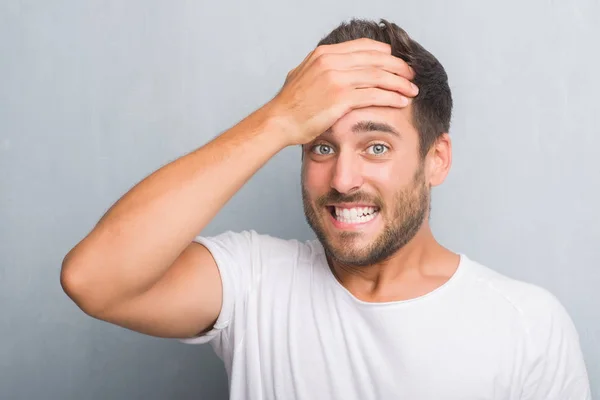 Guapo Joven Sobre Pared Gris Grunge Estresado Con Mano Cabeza — Foto de Stock